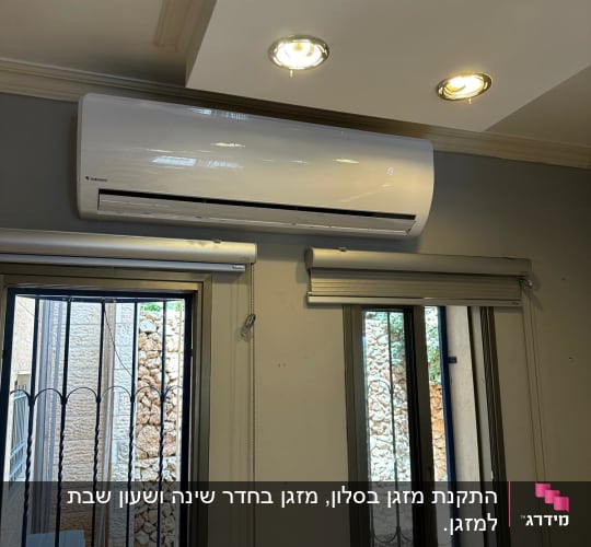מזגן קיר לבן מותקן על קיר אפור